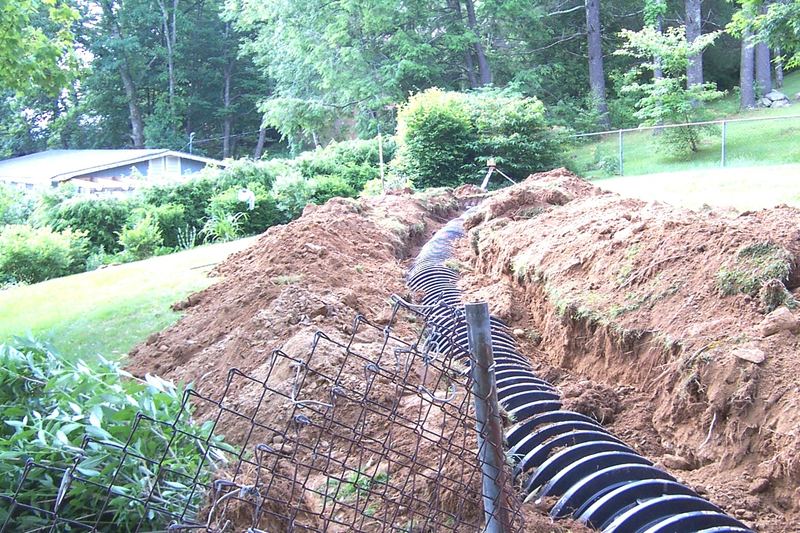 Corrugated pipe running down a trench on a garden slope